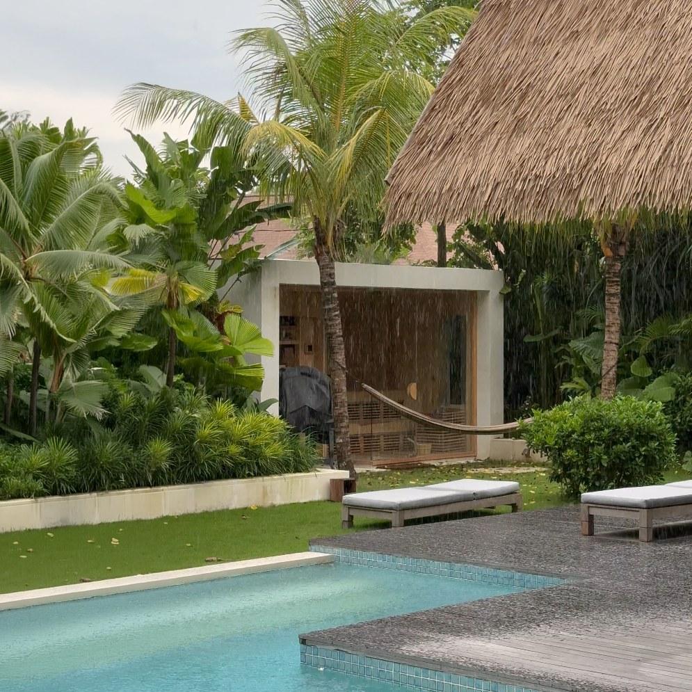 Thorp House in Bali under heavy rain, pool and thatched roof in the foreground