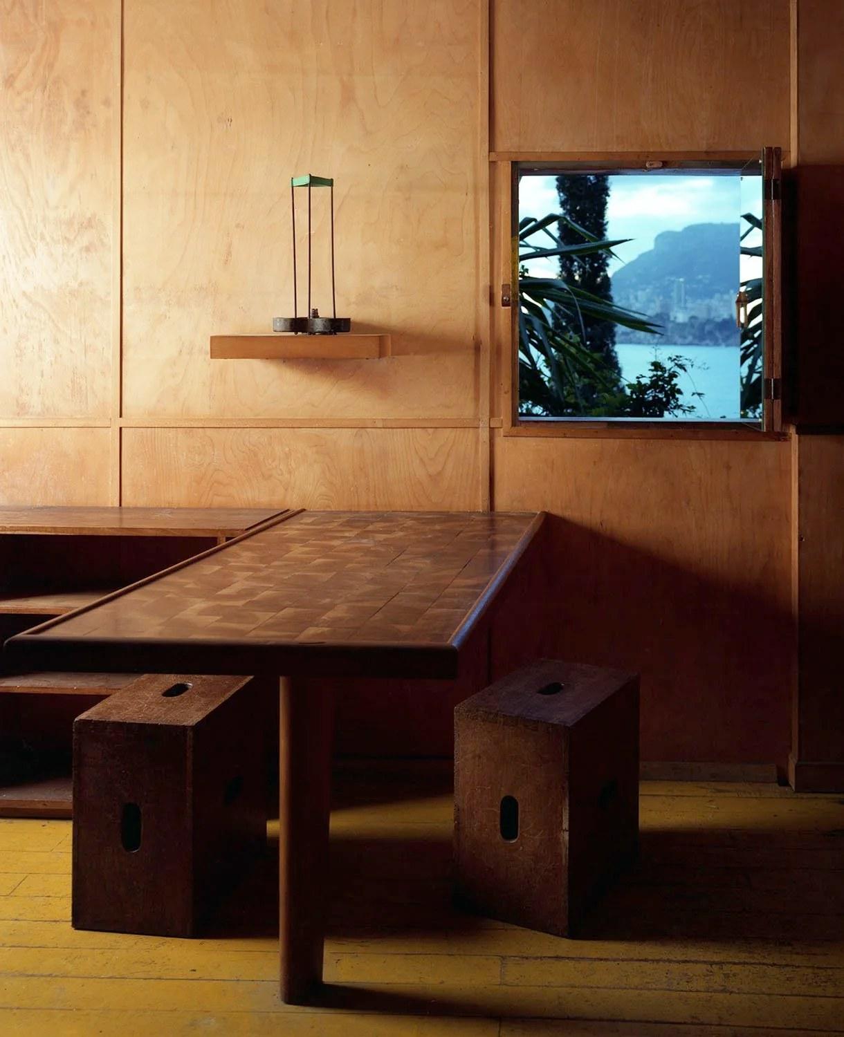 Inside Le Corbusier's cabanon at Roquebrune-Cap-Martin: plywood walls, a table and a small window onto the sea