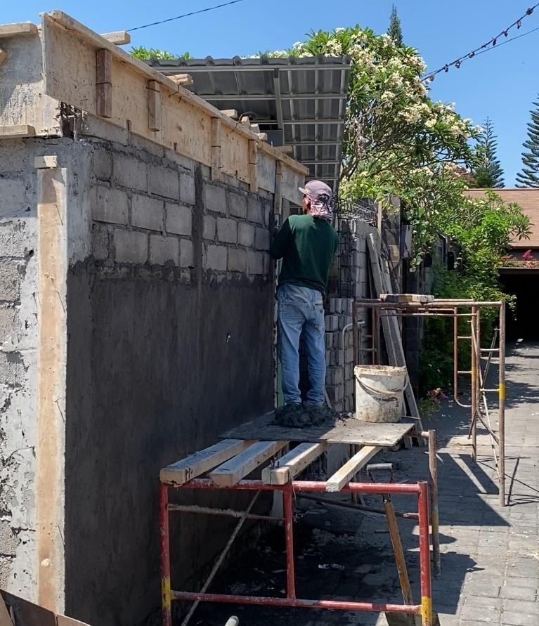 Blockwork wall being plastered on a building site