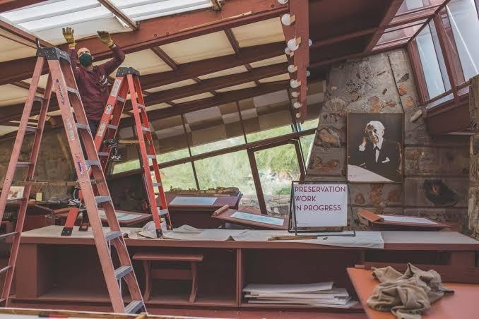 Preservation work at Taliesin West: a worker on a ladder beneath the drafting studio roof