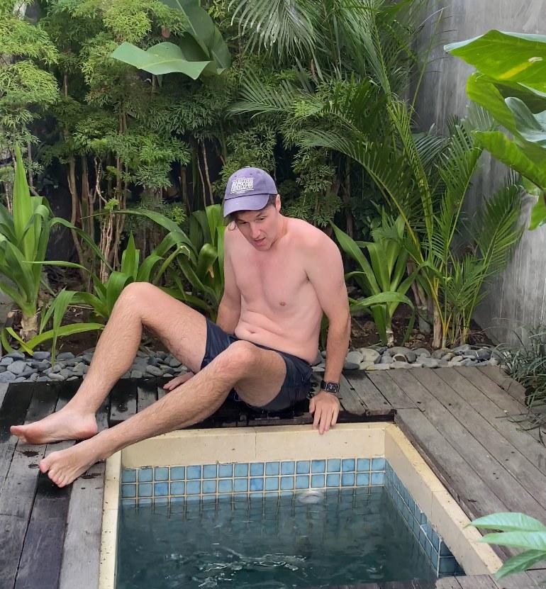 Danny sitting on the edge of a small tiled cold plunge