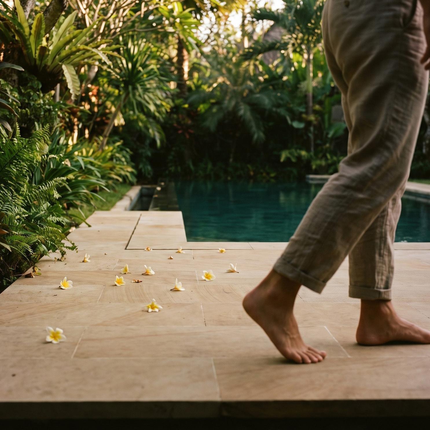 Bare feet walking on a stone pool terrace